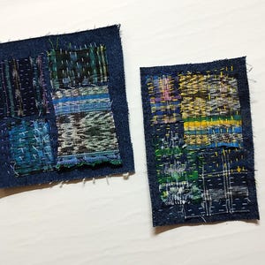 Może przedstawiać: Dwie łatki z tkaniny w kolorze indygo z widocznymi szwami. Każda łatka ma wzór patchworkowy z różnych teksturowanych tkanin w odcieniach niebieskiego, zielonego i żółtego. Krawędzie łatek są postrzępione.