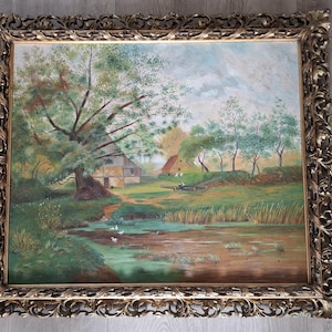 May include: An antique landscape painting in a gold ornate frame. The artwork depicts a rural scene with a pond, trees, and a building. The painting has a vintage aesthetic, with muted colors and visible brushstrokes.