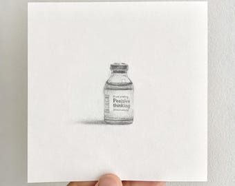 Puede incluir: Un dibujo a lápiz de grafito sobre papel blanco que representa un pequeño frasco de medicina de vidrio. La etiqueta del frasco presenta el texto Positive thinking. La ilustración muestra un sombreado detallado y una sombra proyectada a la izquierda.
