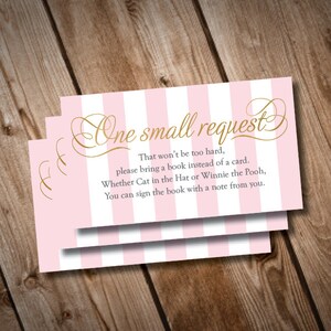 Peut inclure: Carte rayée rose et blanche avec une inscription dorée "One small request". Le texte sur la carte est "That won't be too hard, please bring a book instead of a card. Whether Cat in the Hat or Winnie the Pooh, You can sign the book with a note from you."