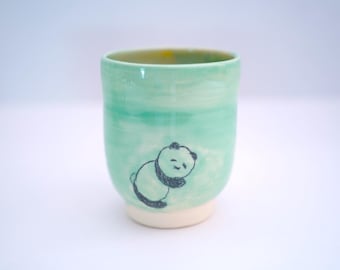 Taza de cerámica hecha a mano con diseño de panda durmiendo.