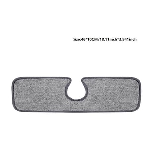 May include: A rectangular gray cleaning pad with a curved cutout. The pad is 18.11 inches long and 3.941 inches wide. The pad has a dark gray border.