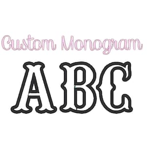 May include: The text Custom Monogram is written in a light pink cursive font above the letters A, B, and C. The letters are rendered in a bold, black, serif-style font with a distinct outline, presented against a plain white background.