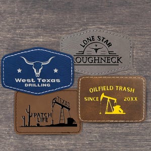 Può includere: Quattro toppe rettangolari ed esagonali con bordi cuciti. Una toppa blu presenta un teschio di longhorn e il testo West Texas Drilling. Una toppa grigia mostra un teschio di longhorn e il testo Lone Star Roughneck. Due toppe marroni con grafiche.