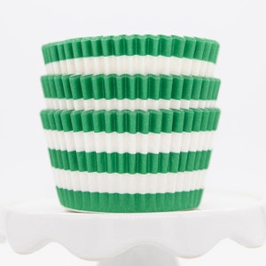 May include: Green and white striped cupcake liners. The liners are stacked on top of each other.