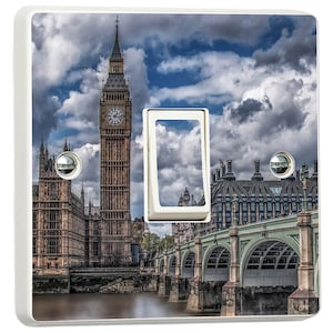 May include: A white light switch cover with a photographic print of the Elizabeth Tower (Big Ben) and the Houses of Parliament in London. The image shows Westminster Bridge and a dramatic, cloudy sky.