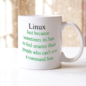 May include: White ceramic mug with a curved handle. The mug features the word "Linux" in black, with a green text below that reads: "Just because sometimes its fun to feel smarter than people who can't use a command line."