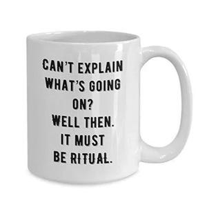 May include: White ceramic mug with a curved handle. The mug features black text that reads: "CAN'T EXPLAIN WHAT'S GOING ON? WELL THEN. IT MUST BE RITUAL."