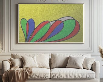 May include: A framed abstract art piece with a yellow textured background. The artwork features overlapping, stylized shapes in red, green, blue, and white. The piece is displayed above a beige sofa with pillows and a throw blanket.