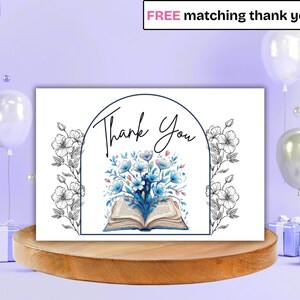 May include: A white card with the words "Thank You" in script, surrounded by floral illustrations and a watercolor image of flowers and an open book. The card is on a wooden stand, with balloons and gifts in the background.