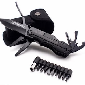 May include: A black multi-tool with a serrated blade and various attachments, including pliers and bottle openers. The blade has the text "YOUR TEXT HERE". Includes a black carrying case and a set of screwdriver bits.