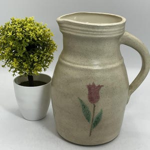 Puede incluir: Un letrero de madera rústico con el texto "Welcome to our home" en un estilo manuscrito. El letrero presenta un acabado envejecido y un diseño sencillo y acogedor, ideal para un porche.