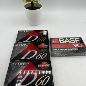 May include: Three TDK D60 audio cassette tapes with black and red packaging and one BASF Performance Series 90 audio cassette tape with black and red packaging. Each TDK tape features the text D60, and the BASF tape features the text BASF 90.