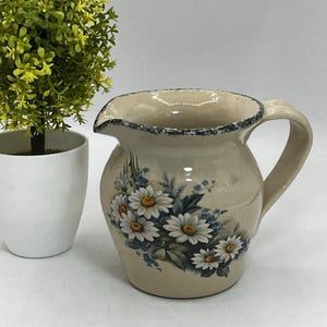 May include: A set of three ceramic mugs with a speckled, matte finish. The mugs are in shades of cream, light gray, and dark gray. Each mug has a simple, minimalist design, perfect for coffee or tea.