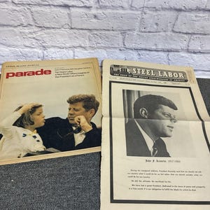 Lote de itens diversos de JFK Kennedy, edição comemorativa do trabalho na indústria siderúrgica de 1963 e edição especial da revista Parade Caroline de 1973.