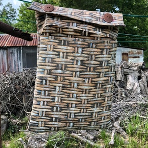 May include: A brown and white woven fabric pouch with two brown buttons. The pouch is hanging on a clothesline.