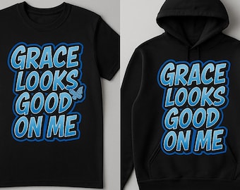 May include: Black t-shirt and hoodie with the text "GRACE LOOKS GOOD ON ME" in blue and white. The t-shirt is short-sleeved, and the hoodie has a hood. A butterfly graphic is on the t-shirt.