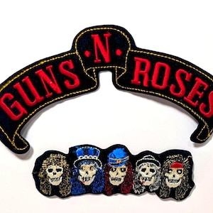 May include: Embroidered patches featuring the Guns N' Roses logo and a band of skull-faced characters. The banner-style logo is black with red lettering and gold trim. The skull band members have various hair colors and hat styles.