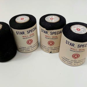 May include: Four spools of black Star Special mercerized thread. Each spool features a tan paper label with red text and a star logo, reading Star Special, Will Boil, Mercerized, Three Cord Cotton, American Thread Co., New York, N.Y., U.S.A.