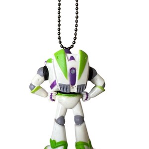 Puede incluir: Una figura de Buzz Lightyear, vista desde atr&aacute;s, de pie sobre una base gris. El juguete presenta un cuerpo blanco con detalles verdes y morados, y una cadena negra para colgar. La figura tiene los brazos en las caderas.