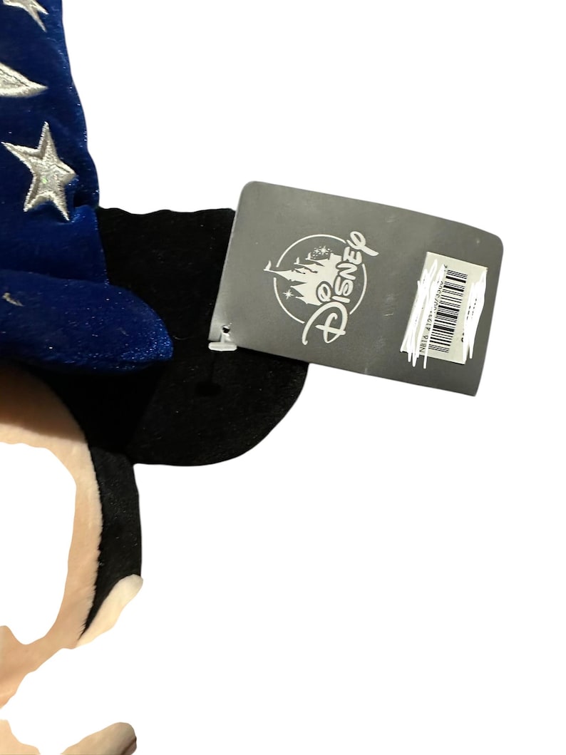 May include: A plush Mickey Mouse ear headband with a blue velvet wizard hat featuring silver stars. A Disney tag is attached to the headband.