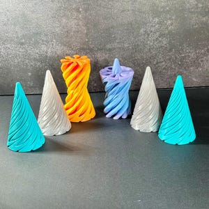May include: Five 3D printed cones, two are turquoise, one is silver, one is orange, and one is purple. The cones are all different sizes and have a spiral design.