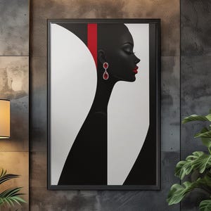 Puede incluir: Una impresión artística enmarcada que presenta un retrato minimalista de perfil. La obra de arte es principalmente en blanco y negro, con una franja y pendientes rojos que añaden un toque de color. La impresión cuelga de una pared gris texturizada, encima de una silla y una mesa auxiliar.