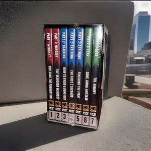 May include: A boxed set of seven DVDs. The spines are colour-coded in red, blue, and green, with white text. Titles include "Mindset," "Training," and "Gear." The DVDs are numbered 1 to 7.