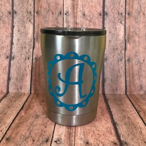 May include: A stainless steel tumbler with a blue and white monogram decal featuring the letter "A".