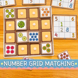 May include: A number grid matching game featuring a four-by-four board with orange squares and white circular markers. Several square tiles depicting various fruits, including kiwi, watermelon, oranges, blueberries, and strawberries, are placed on the grid.