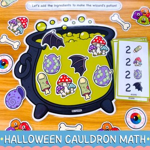 May include: A wizard's potion math activity set featuring a large black cauldron filled with green liquid, surrounded by cutouts of mushrooms, bat wings, bones, eyeballs, and monster creatures, plus cards with the number 2 and matching icons.