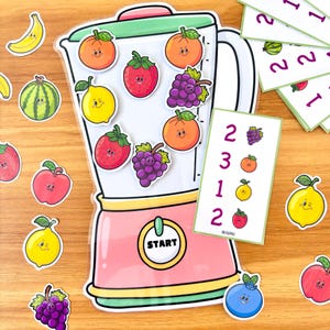 May include: A colorful educational toy set featuring a pink and green blender with fruit magnets and number cards. The fruit magnets include oranges, strawberries, grapes, and lemons. The number cards display fruit and numbers.