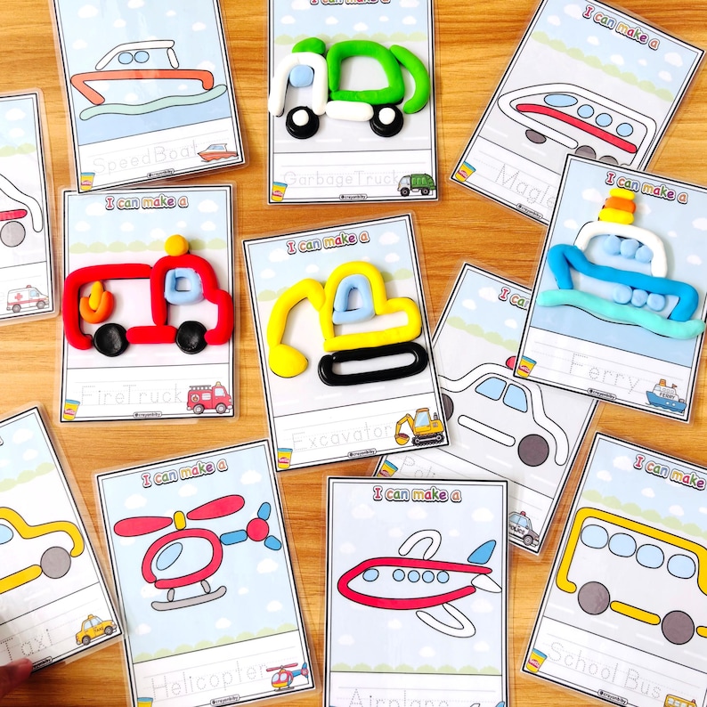 Op de afbeelding: Een verzameling activiteitkaarten met transportthema. Elke kaart toont een lijntekening van een voertuig, zoals een brandweerwagen, helikopter of schoolbus, met een bijpassend kleimodel. De kaarten liggen op een houten oppervlak.