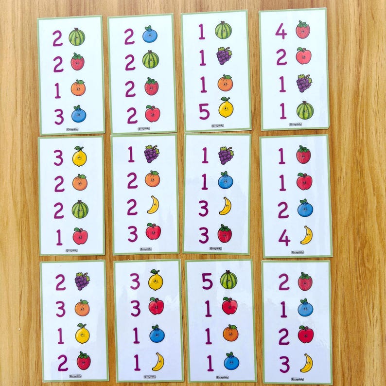 May include: A collection of educational flashcards featuring numbers and colorful fruit illustrations. Each card displays a number and a corresponding set of fruits, such as apples, grapes, and watermelons. The cards are designed for learning and counting.