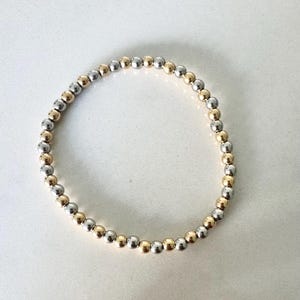 Tweekleurige kralenarmband met 18 kt goud en rhodium, sierlijke armband