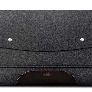 May include: A gray felt laptop sleeve with a brown leather flap and the text "pack & smooch" in white.