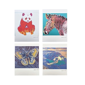 May include: Four art prints featuring animal illustrations. The prints include a panda bear, a zebra, a butterfly, and a sea turtle. Each print has a white border and a signature in the bottom right corner.