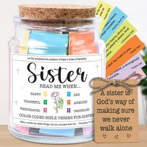 May include: A glass jar with a cork lid, filled with colorful Bible verse cards. The jar has a label that reads "Sister, Read Me When..." and includes color-coded verses for different emotions. A small tag reads "A sister is God's way of making sure we never walk alone."