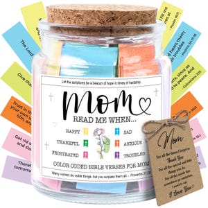 May include: A glass jar with a cork lid filled with colorful Bible verses for Mom. The jar has a label that reads "Mom, Read Me When..." with various emotions listed. A small tag with a message of love hangs from the jar.
