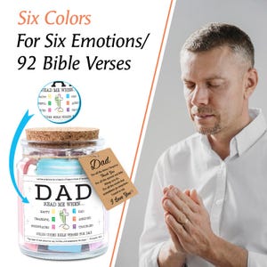 May include: A glass jar with a cork lid, labeled "DAD" and "READ ME WHEN..." with color-coded Bible verses for six emotions. A tag reads "Dad, I Love You." The text "Six Colors For Six Emotions/92 Bible Verses" is at the top.