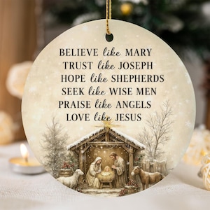 May include: A round ceramic ornament featuring a nativity scene with Mary, Joseph, and a baby in a manger, accompanied by a sheep and a donkey. The text reads: BELIEVE like MARY, TRUST like JOSEPH, HOPE like SHEPHERDS, SEEK like WISE MEN, PRAISE like ANGELS, LOVE like JESUS.