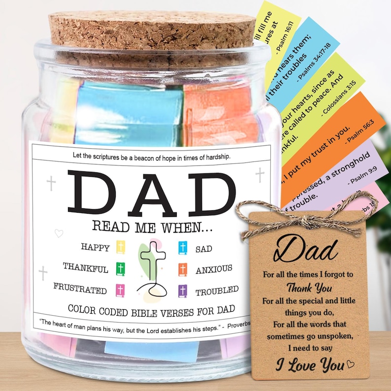 May include: A glass jar with a cork lid, filled with colorful Bible verses for Dad. The jar has a label that reads "DAD" and "Read Me When..." with various emotions. A small tag says "I Love You."