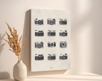 Può includere: Stampa su tela con dodici fotocamere vintage in bianco e nero, disposte a griglia. Le fotocamere sono disposte in tre file da quattro, su uno sfondo beige neutro. La stampa è montata su una parete.