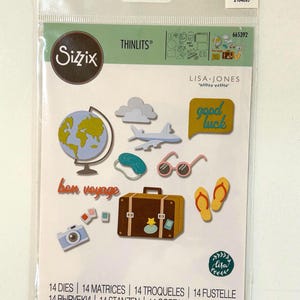 May include: A package of Sizzix Thinlits paper craft dies featuring travel-themed designs. Includes a globe, airplane, suitcase, sunglasses, flip-flops, and the words "bon voyage" and "good luck". The package also includes the text "14 DIES | 14 MATRICES | 14 TROQUELES | 14 FUSTELLE".