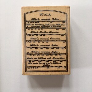 May include: A wooden stamp with the word "SCALA" at the top and a table of distances in Roman numerals and numbers. The table lists distances in "Milliaria" for different regions, including Gallica, Hispanica, Germanica, Dalica, and Anglica.