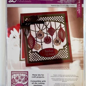 May include: A metal die for craft projects, featuring a Christmas ornament design with a red and gold color scheme. The die is compatible with all die cutting machines. The packaging includes the text "Deck the Halls" and "Christmas Wishes".