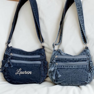 May include: Two denim crossbody bags with adjustable straps. Each bag has multiple zippered compartments and a small side pocket. One bag has the name "Lauren" embroidered in white script on the front.