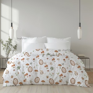 May include: White bedding featuring a pattern of brown hedgehogs, mushrooms, and leaves. The bedding is on a bed with two white pillows. The text "DesignByPlaya" is visible on the pillows.