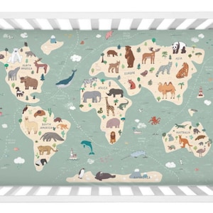 Könnte beinhalten: Ein grünes und beiges Kinderbettlaken mit einem Weltkarten-Design, das Tiere aus verschiedenen Kontinenten zeigt. Die Kontinente sind mit ihren Namen beschriftet, wie z. B. Nordamerika, Südamerika, Europa, Asien, Afrika und Australien. Das Laken ist aus weichem, atmungsaktivem Stoff gefertigt und perfekt für das Kinderzimmer eines Babys.