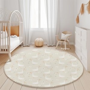 May include: A round, beige play mat with a white goose pattern. The mat is in a nursery with a white crib and a wooden chair.
